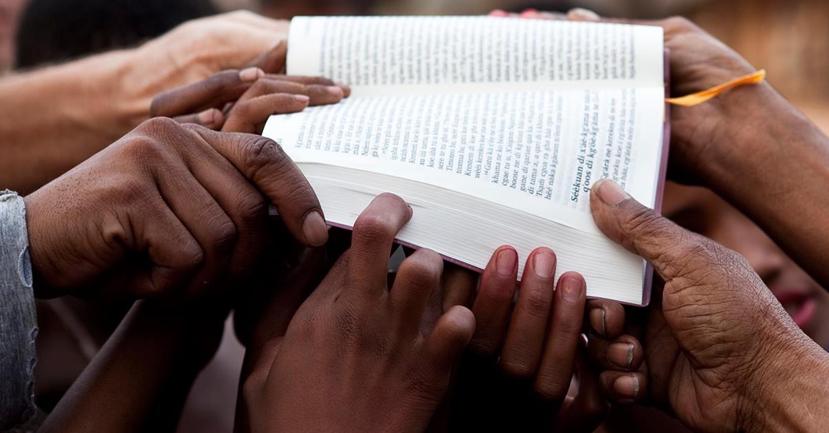 Photo of Bible held by many people Photo of Bible held by many people